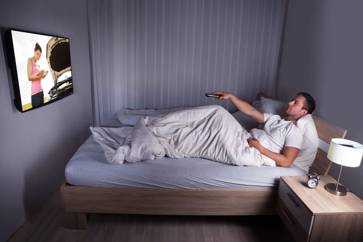 Man watching TV in bed