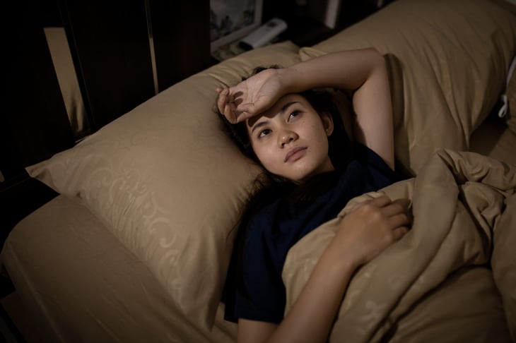 Woman lying in bed, unable to sleep