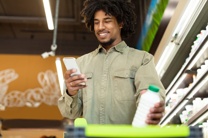 Shopper using a smartphone at a grocery store