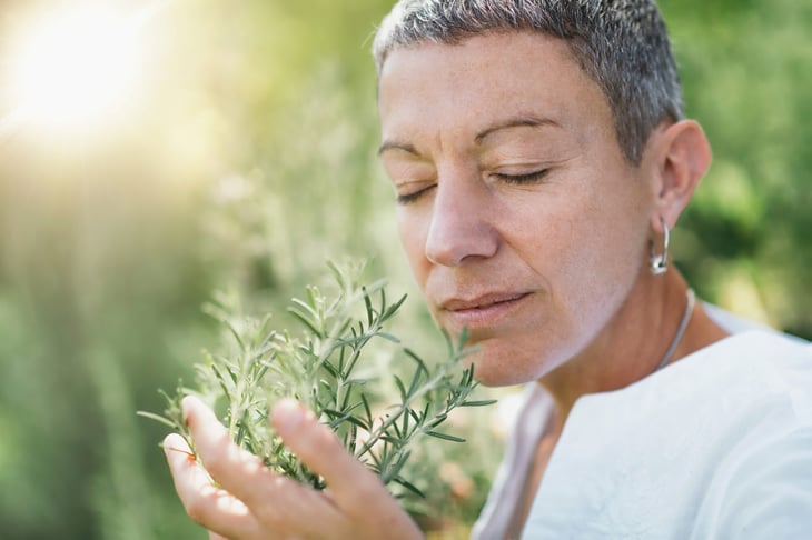 Woman smelling fresh herbs