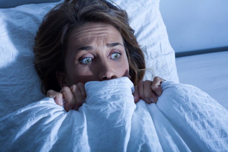 Scared woman in bed