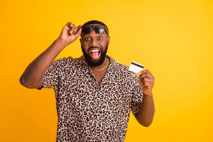 Excited man ready for vacation with credit card rewards