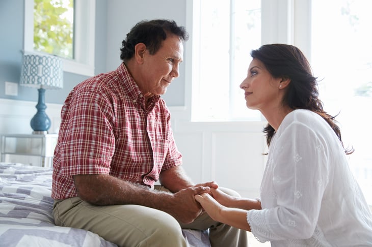 Adult daughter comforting her father with dementia