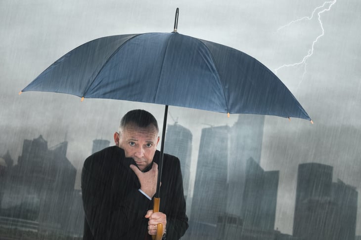 Worried senior man with an umbrella