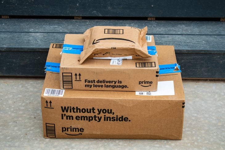 A stack of Amazon Prime packages sit on a residential doorstep