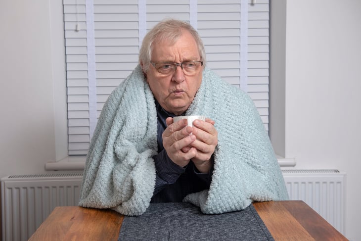 Senior man wrapped in blanket