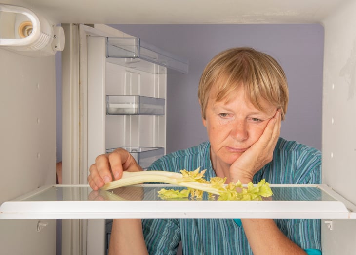 Senior woman with empty fridge