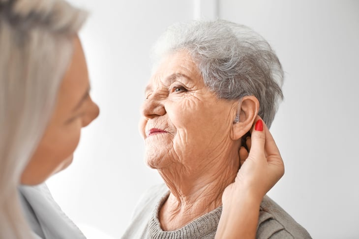 Woman getting hearing aid adjusted