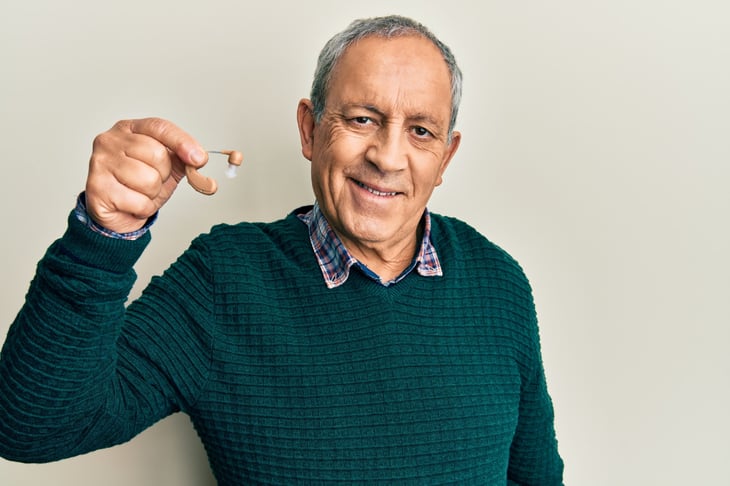man holding hearing aid