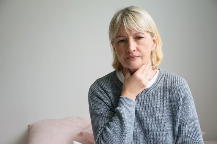 Senior woman touching her neck