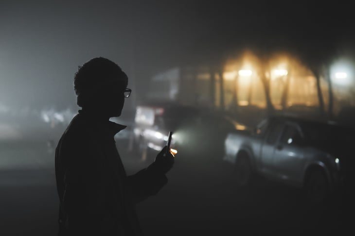 man with flashlight on phone