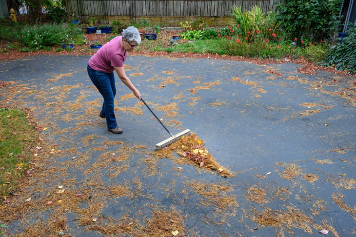 Woman sweeping driveway