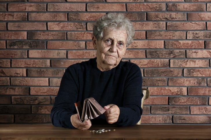 Unhappy senior woman with empty wallet