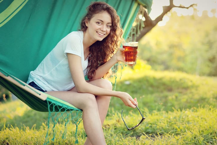 Girl on hammock drinking ice tea iced tea