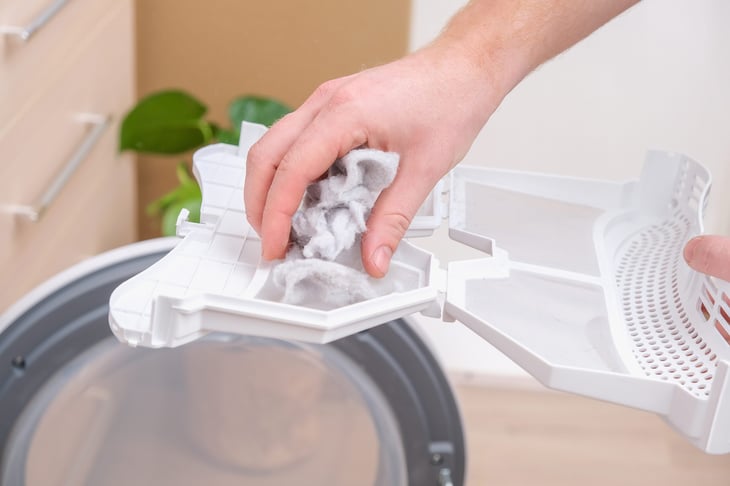 Man cleaning a clothes dryer lint filter