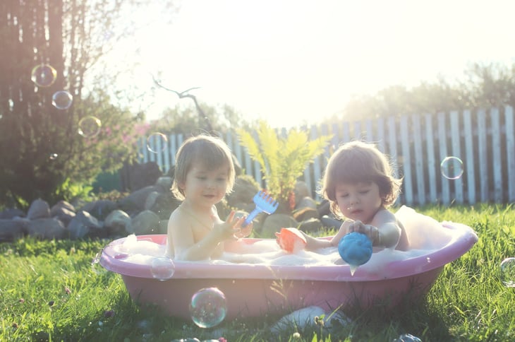 children playing outside in the bathtub