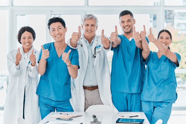 Doctors and nurses giving thumbs up in a hospital
