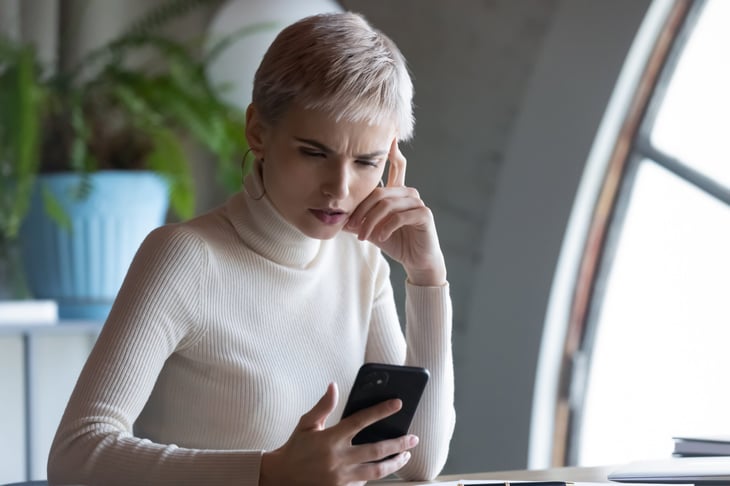 Woman working from home looks at here phone