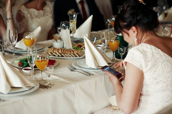 Woman using cell phone at wedding