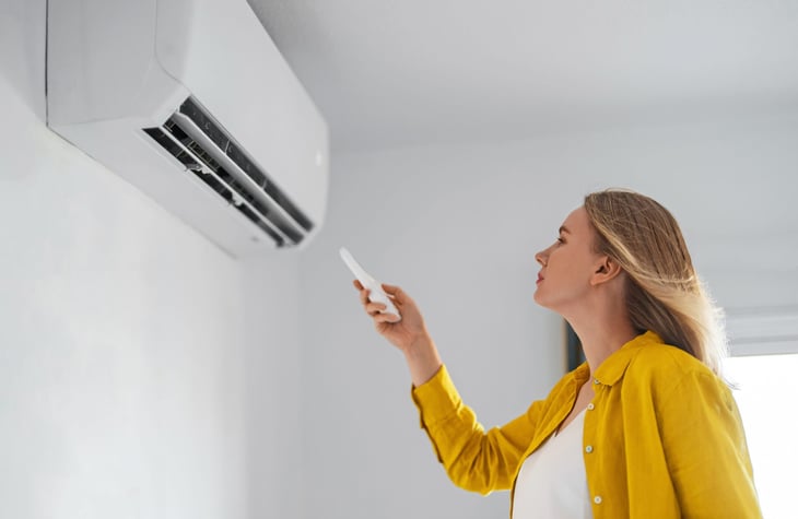 Woman turning off air conditioner