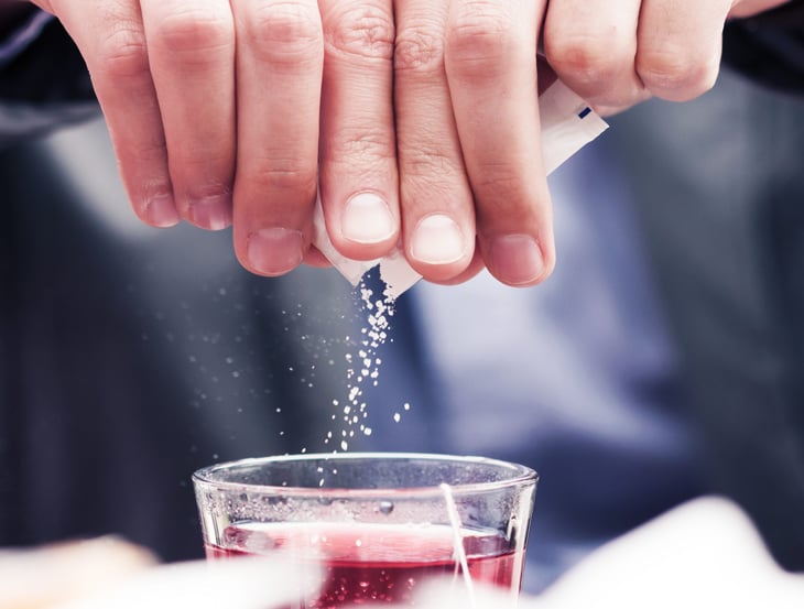 Person sweetening a drink