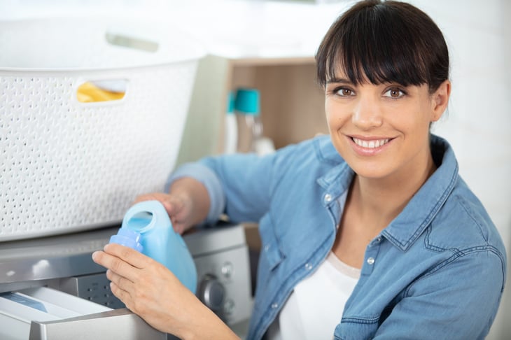 Woman pouring laundry detergent