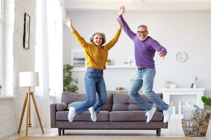 energetic senior couple jumping for joy