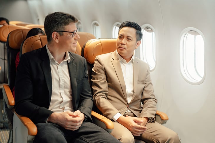 Two men talking on a plane flight