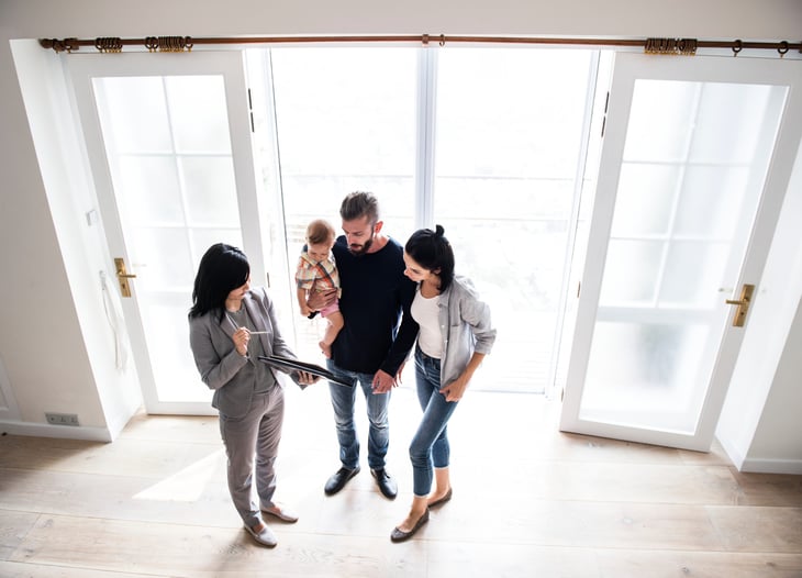 Homebuyer family with a baby tour a new house with a real estate agent