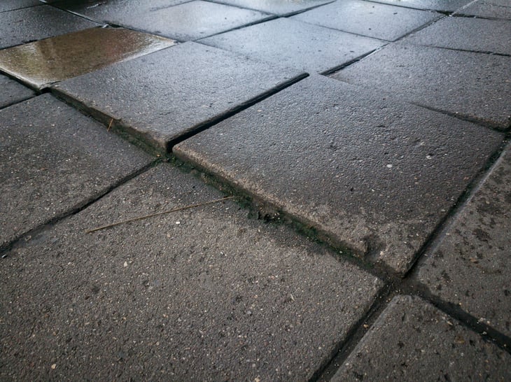 Uneven stone tiles on walkway and danger of tripping and falling