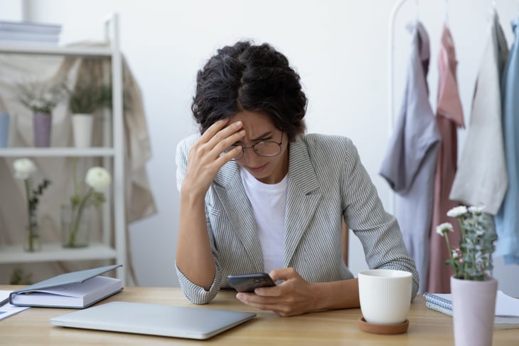 Stressed woman looking at her phone