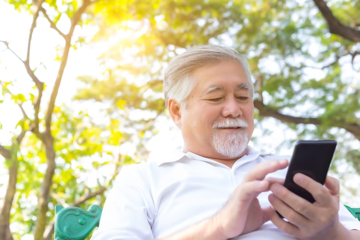 Senior man uses his smartphone for banking