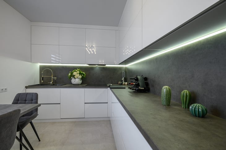 Luxurious modern trendy white and grey kitchen interior after renovation, with stone counter top