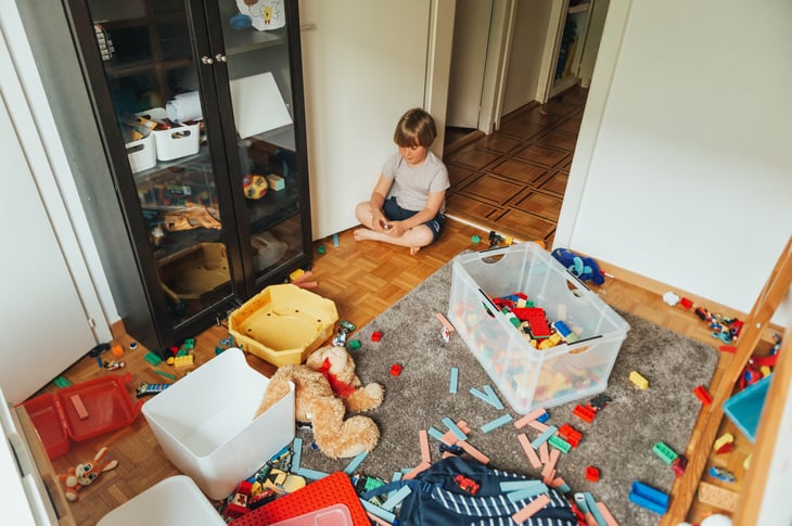 child in cluttered room