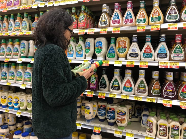 Woman shopping for salad dressing
