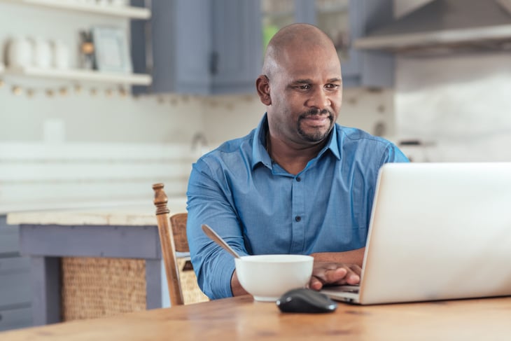 A man using a laptop in his kitchen