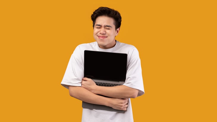 Happy man hugging his laptop because he loves the internet and his service provider