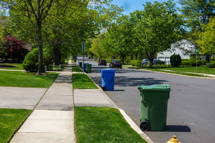Trash bins or garbage cans sitting on the curb for pickup