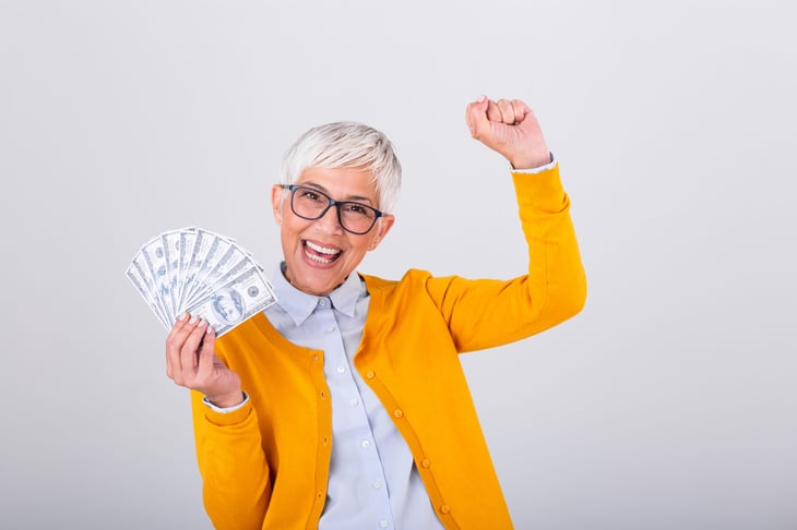 Older woman excited with cash