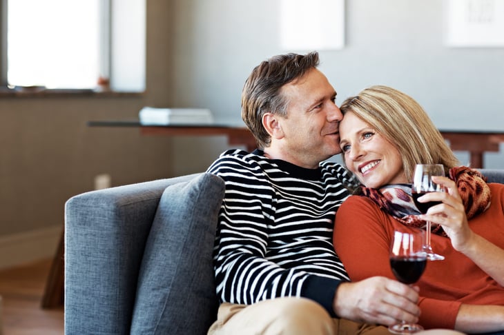Couple drinking wine and celebrating their last mortgage payment at home
