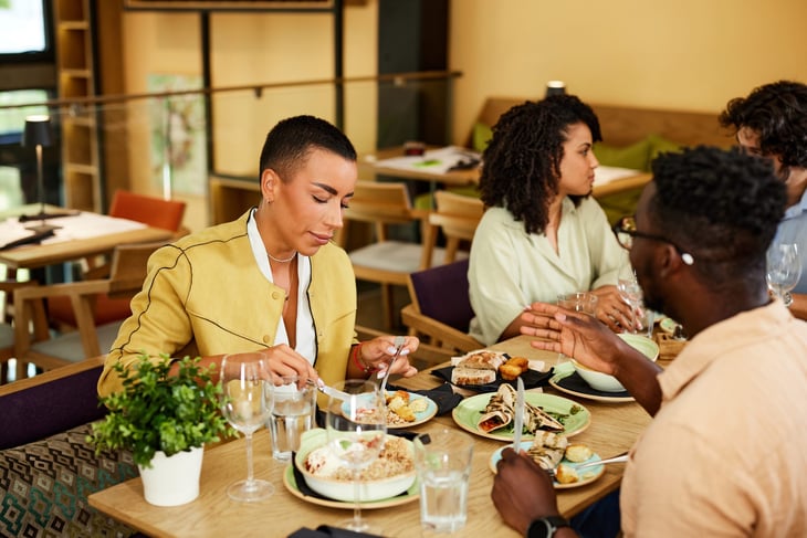Man talking at dinner and interrupting a woman who was speaking at a restaurant
