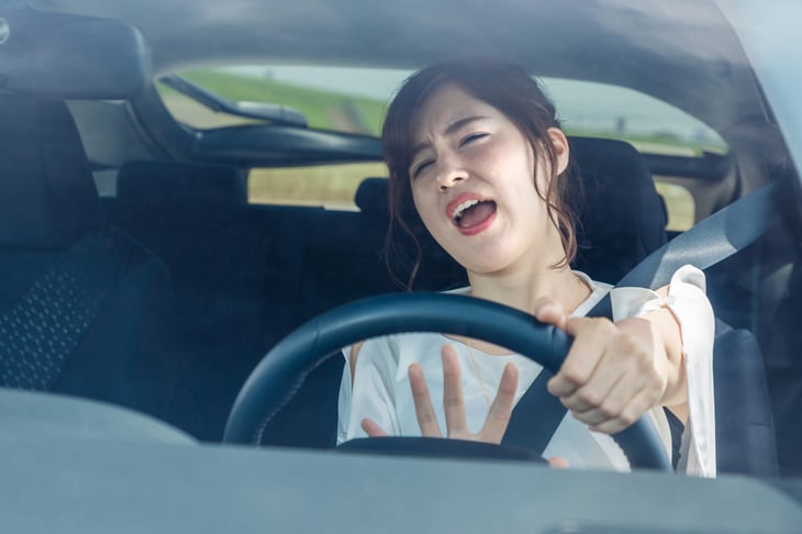 Frustrated female driver stuck in traffic screaming and honking horn