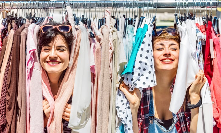 Two women rack of used clothes