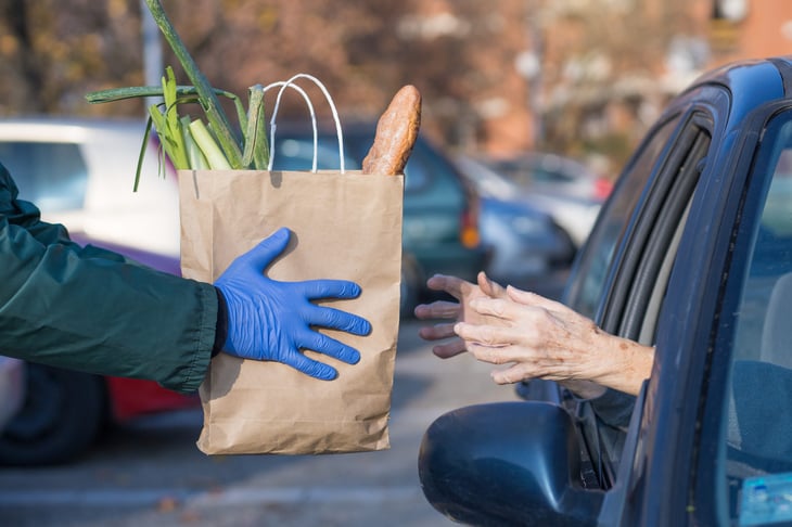 Elderly woman receiving free groceries or grocery delivery or curbside pickup