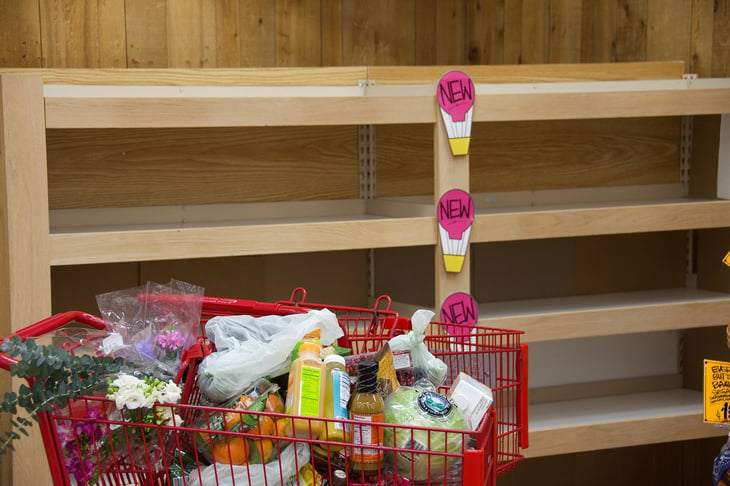 Empty shelves and a grocery cart in Trader Joe's