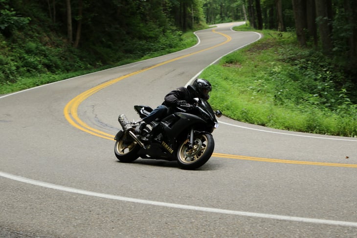 Motorcycle rider on a tight turn riding The Tail of the Dragon in North Carolina