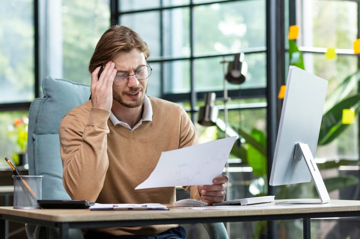 Frustrated man looking at bill