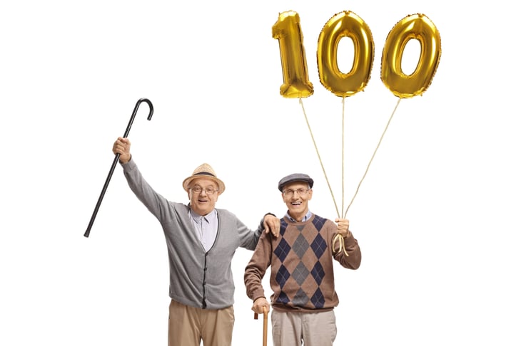 two older men with canes and 100 balloons