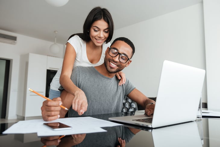 Happy couple doing taxes budgeting