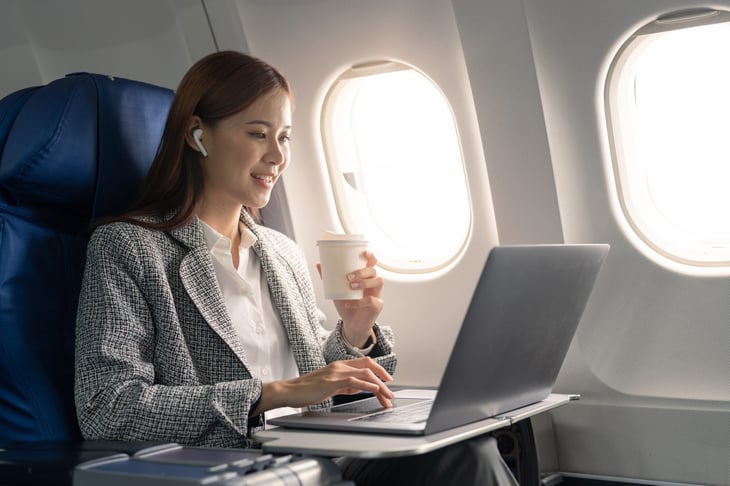 Woman using her laptop on an airplane